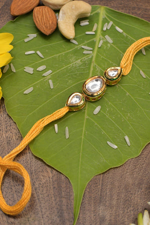 Gold Tone Kundan Rakhi With Yellow Cotton Thread